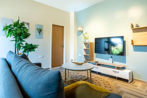 a living room with a blue couch and a table at BIRD NEST Near Arkan Plaza in Cairo