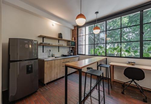 a kitchen with a refrigerator and a table and chairs at The Somos Flats Laureles in Medellín