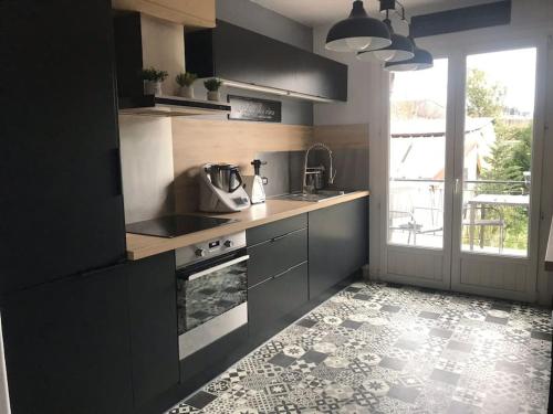 une cuisine avec un évier et une cuisinière dans l'établissement Quartier calme, terrasse plein sud, jardin, à Étaples