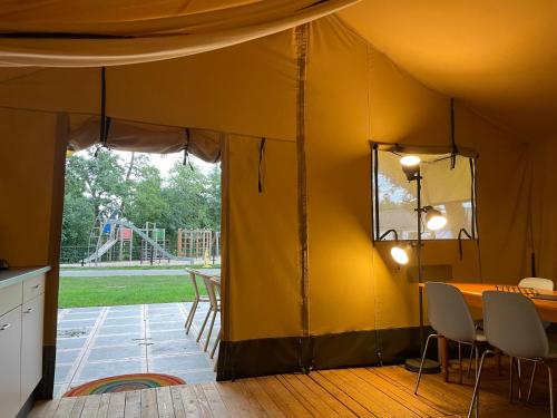 Camping Engelbert (Groningen) في خرونينغن: خيمة مع طاولة وكراسي وملعب