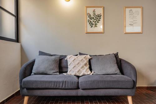 a blue couch in a living room with two pictures on the wall at The Somos Flats Laureles in Medellín