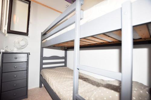 een slaapkamer met 2 stapelbedden en een dressoir bij App. centre ville, parking privé in Port Leucate