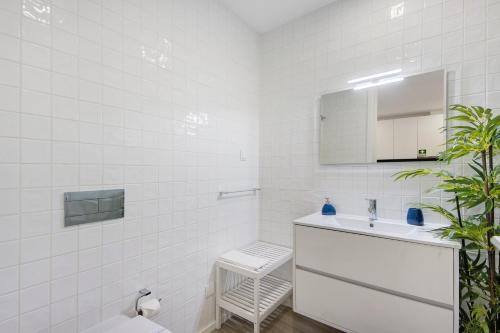 La salle de bains blanche est pourvue d'un lavabo et d'un miroir. dans l'établissement Aveiro City Blue, à Aveiro
