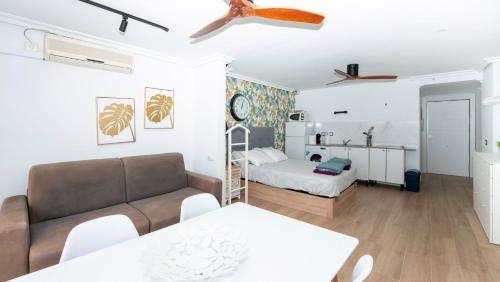 ein Wohnzimmer mit einem Sofa und einem Bett in der Unterkunft Torre Coblanca in Benidorm