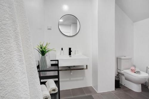a white bathroom with a sink and a toilet at Babosas Charm in Funchal