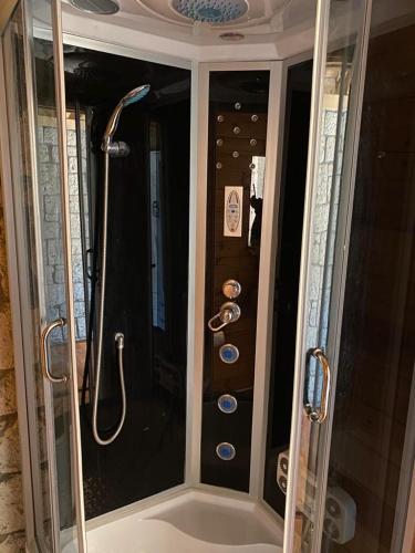 a bathroom with a shower and a tub with a shower at Aral Turkuaz in Çeşme