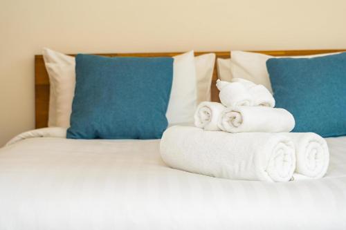 a pile of towels on a bed with blue pillows at ApartHotel Riviera - Amazing large 3 bedrooms with Sea View AC - Old Town- Promenade des Anglais - SEA VIEW in Nice