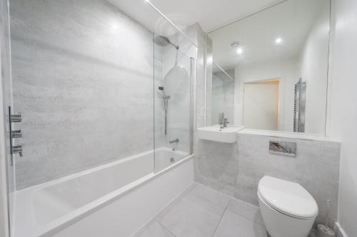 a white bathroom with a toilet and a shower at Stylish 2 bedroom Apartment in Central london in London