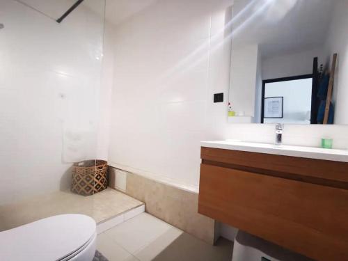 La salle de bains est pourvue d'une baignoire, de toilettes et d'un lavabo. dans l'établissement Appart' Bleu Soleil, à Filaos