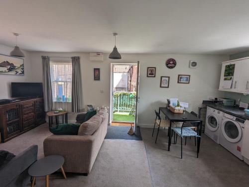 a living room with a couch and a table at Namastay-Central Glastonbury in Glastonbury