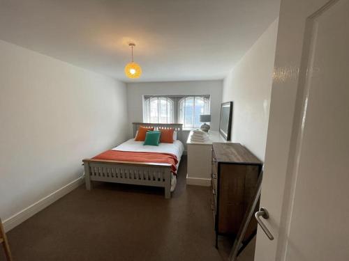 - une chambre avec un lit, une commode et une fenêtre dans l'établissement Super Duplex with Free Parking, à Plymouth