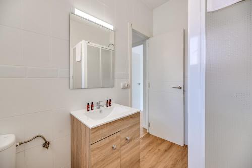 a white bathroom with a sink and a mirror at LXR Vistahermossa 3BDR. Apt Next to sea in Fuengirola