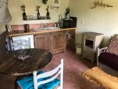 - une cuisine avec une table et un évier dans l'établissement Maison de hobbit montcuq, à Montlauzun