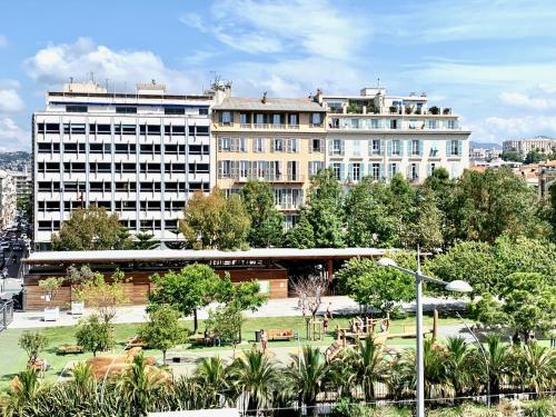 un gran edificio con un parque enfrente en ApartHotel Riviera - Nice Côte d'Azur - Old Town - Promenade des Anglais, en Niza