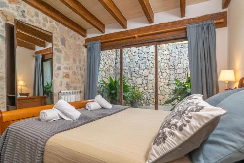a bedroom with a large bed and a large window at El Ciprés in Sant Llorenç des Cardassar