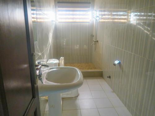 a bathroom with a sink and a toilet and a shower at Home Sweet Home Heritage Inn in Accra