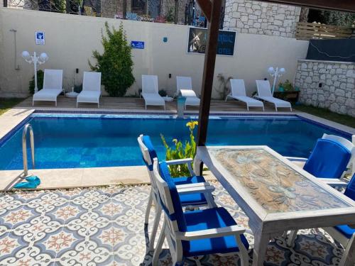 - une piscine avec des chaises, une table et une table dans l'établissement Aral Turkuaz, à Çeşme