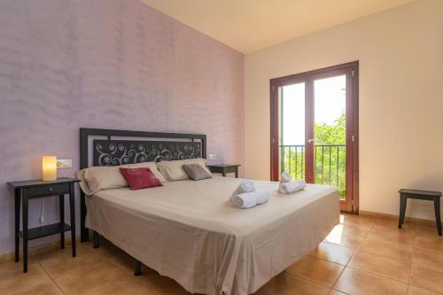 ein Schlafzimmer mit einem großen Bett und einem großen Fenster in der Unterkunft Finca Son Puça in Petra