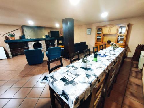 a long long table in a room with a piano at La Pérgola in La Cabrera