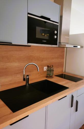 un comptoir de cuisine avec un évier et un micro-ondes dans l'établissement Olydea Le Hameau de Vouvant, à Vouvant