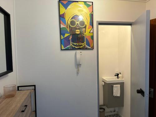 a bathroom with a painting on the wall next to a toilet at Cosy Duplex avec Parking à Paris 19 by immo kit bnb in Paris