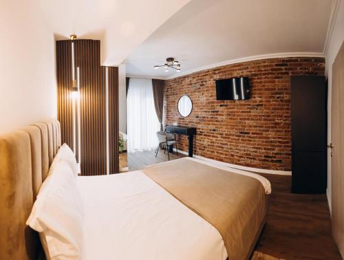 um quarto de hotel com uma cama e uma parede de tijolos em Pensiunea Brici Junior em Cluj-Napoca