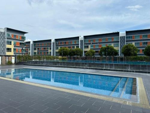 einem Pool vor einem Gebäude in der Unterkunft 3BR Near KKIA Homestay Cyber City Apartment in Kota Kinabalu