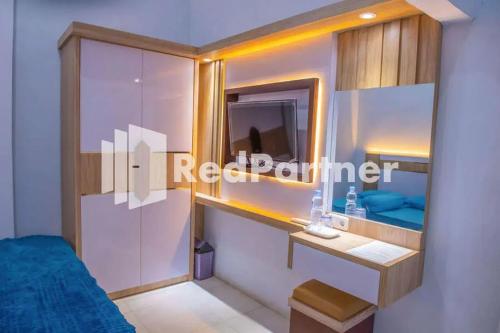 Dormitorio pequeño con cama y espejo en Hotel Rai's Palopo Exclusive Mitra RedDoorz en Palopo