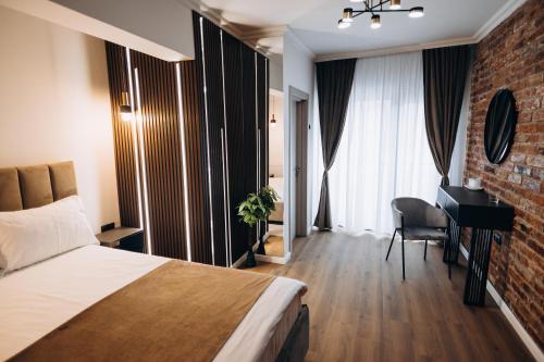 a hotel room with a bed and a desk at Pensiunea Brici Junior in Cluj-Napoca