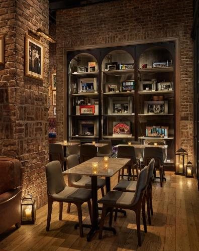 a restaurant with tables and chairs and a brick wall at CIVILIAN Hotel in New York