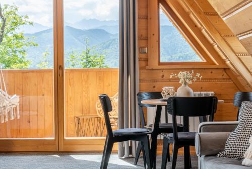 a room with a table and chairs and a large window at Wierchowa Chata in Kościelisko