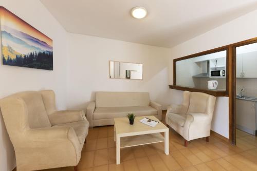 a living room with two chairs and a table at La Solana Apartaments & Spa in Encamp