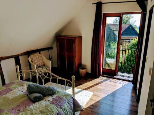 een slaapkamer met een bed en een deur naar een balkon bij Stunning barn conversion ideal for large families in Bildeston