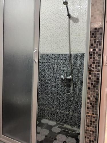 a shower with a glass door in a bathroom at appartement de nouri à marti in Martil