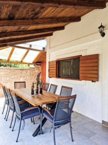a wooden table and chairs on a patio at Holiday home Smokvin Hlad in Peroj