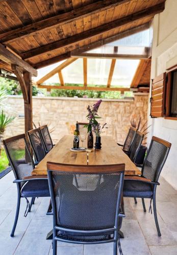 a wooden table and chairs on a patio at Holiday home Smokvin Hlad in Peroj