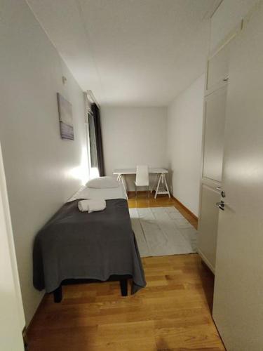 um quarto com uma cama com um cobertor cinzento em Kotimaailma - Avara kolmio saunalla ja meri näkymällä, lähellä Helsingin keskustaa em Helsinque