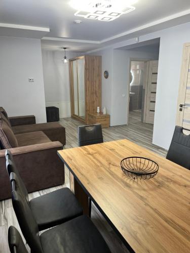 a living room with a wooden table and chairs at Guest House Zatyshnyi Dvir in Bukovel