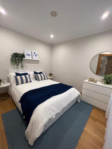 a bedroom with a large bed and a mirror at The Blue Flat Vigo - A ESTRENAR - Apartamento Boutique Deluxe - Centro ciudad in Vigo