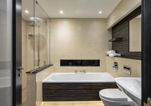 uma casa de banho com uma banheira, um WC e um lavatório. em Stanley House Hotel & Spa em Blackburn