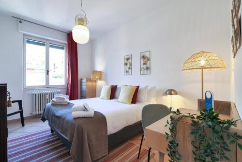 um quarto com uma cama e uma mesa com um candeeiro em Sweet Inn - Modigliani em Milão