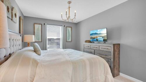 a bedroom with a large white bed and a dresser at 2147 Cooper Bell in Kissimmee