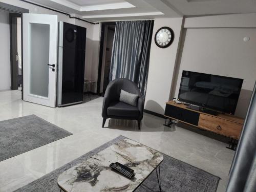 uma sala de estar com uma cadeira e uma televisão em Sahil dairesi em Atakum