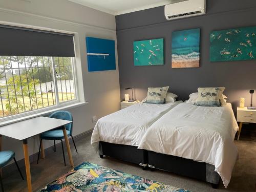 a bedroom with a bed and a desk and a window at Belmont Guest House in Cape Town