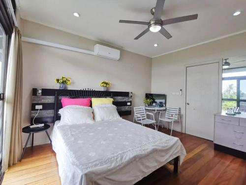 um quarto com uma cama e uma mesa com cadeiras em Master Bedroom in Shared Cozy River View Pool Apartment em Nadi