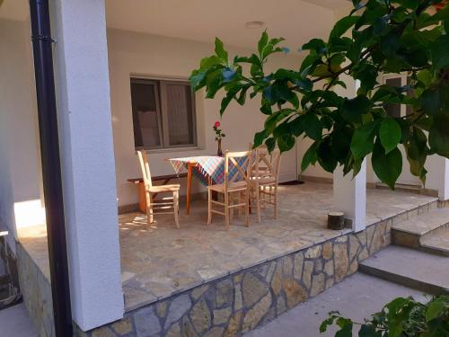 eine Terrasse mit einem Tisch und Stühlen in einem Haus in der Unterkunft Apartman Predah Banja Vrujci in Gornja Toplica