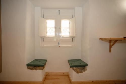 a room with two green benches in front of a window at Óbidos Pátio House in Óbidos