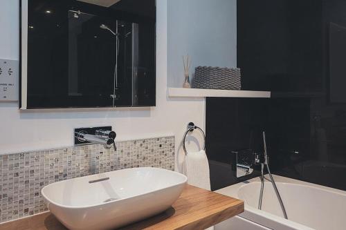 a bathroom with a white sink and a tub at The Neuk in Kincraig