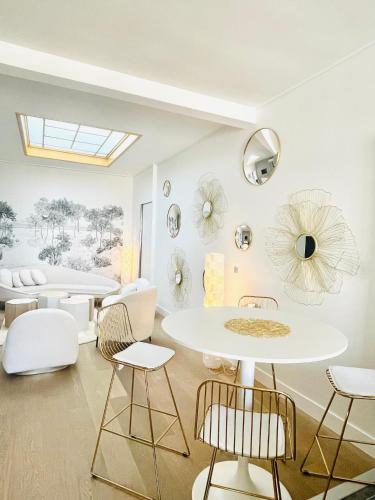 Cette chambre dispose de chaises blanches, d'une table et de miroirs. dans l'établissement Hyper center Sauna air conditionner, à Reims