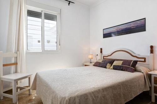biała sypialnia z łóżkiem i oknem w obiekcie Alboran 208 w mieście Conil de la Frontera